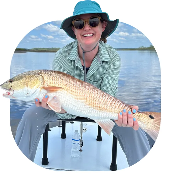 Angler holding a redfish caught on the fly